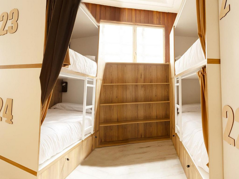 Literas hostel blancas con cortinas burdeos