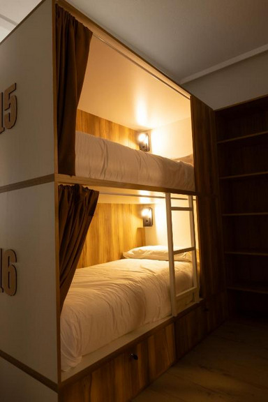 Literas hostel madera con cortinas marron